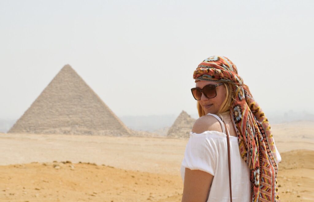 woman standing in front of the pyramids of giza egypt