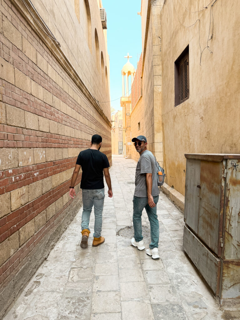 two men walking down an alley in coptic cairo egypt